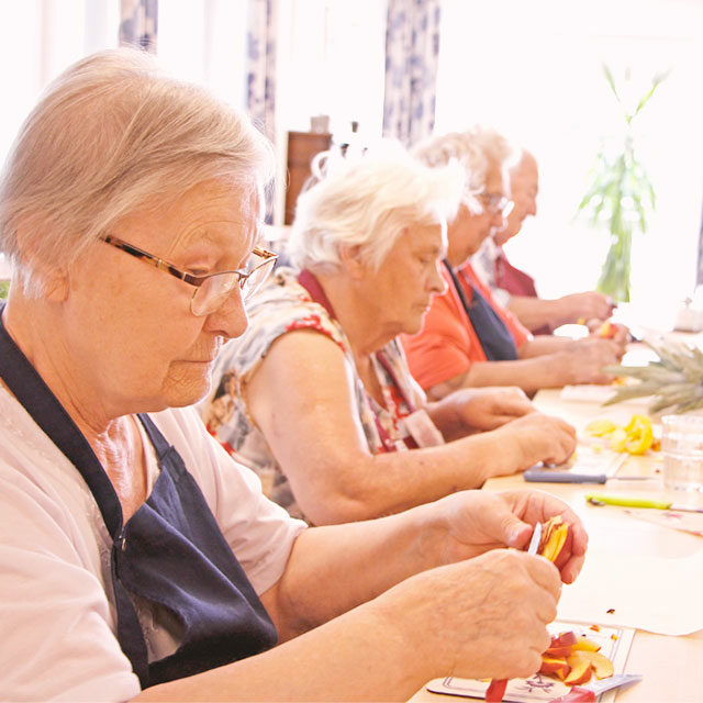 Bewohnter beim Obstschneiden für die Förderung der Selbstständigkeit