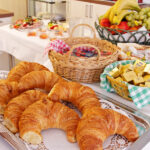 Frühstücksbuffett mit Hörnchen, Saft und frischem Obst