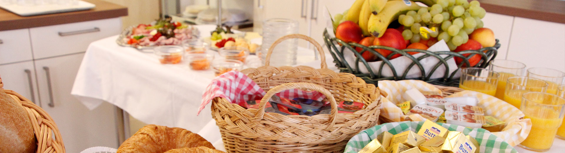 Frühstücksbuffett mit Hörnchen, Saft und frischem Obst