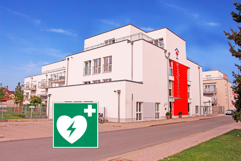 Frontansicht des BRK-Altstadtparks in Bayreuth mit dem grünen Hinweisschild auf einen Defibrillator