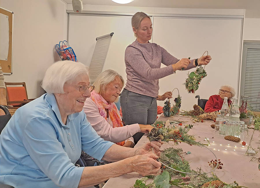 Teilnehmerinnen des ersten Kreativ-Workshops im BRK-Altstadtpark bei der Herstellung von Loops aus herbstliche Naturmateralien.